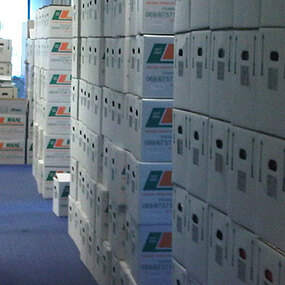 Viele Umzugskartons sind gestapelt in einem Büroflur, bereit für einen Büroumzug.